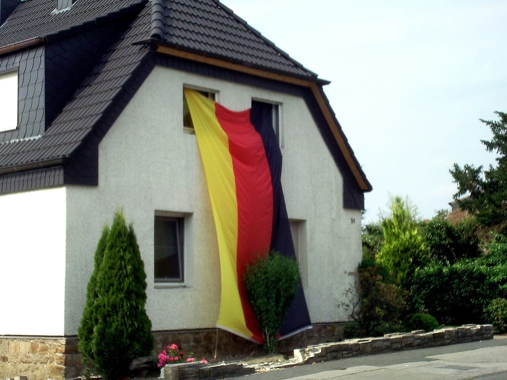 [house with German flag hanging from window]
