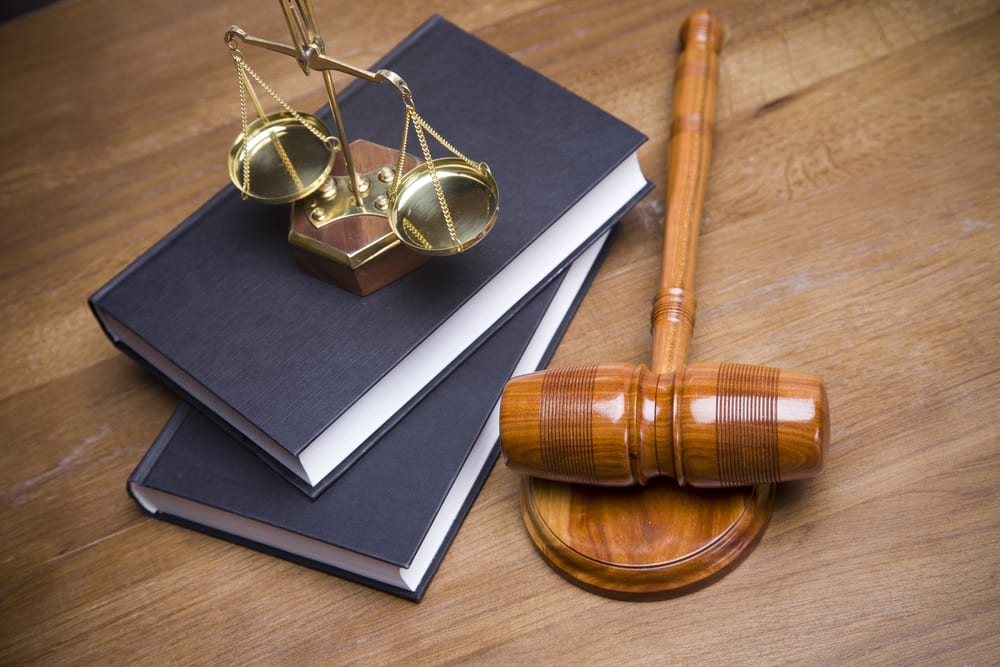 scales of justice on a law book next to a gavel